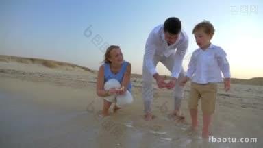 斯坦尼康拍摄的父母和孩子在海岸上有<strong>美好</strong>的<strong>时光</strong>，母亲拿着贝壳，而孩子扔石头